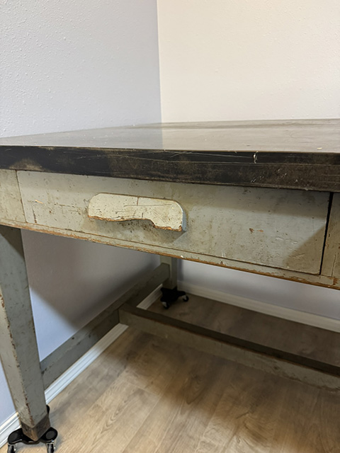 The first handle. The poem has just named it; the photo shows it. The reader sees the broken cream-painted wood with its missing chunk.