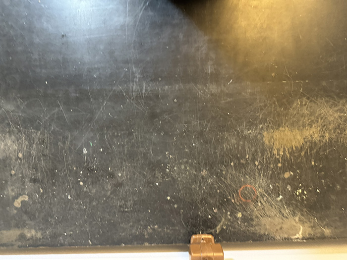 Closes the post on the scarred surface itself — the original site of the father's experimental work, the marks that were hidden by flipping the top. The image is abstract enough that it returns the reader to the poem's opening framing: the inherited material, the work that left these marks, the question of whether to investigate.